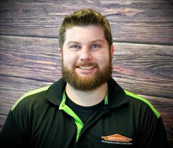 brunette male standing against fake fire backdrop