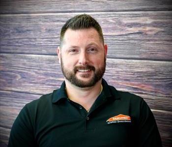 Casey, male crew chief smiling and standing fake fire background