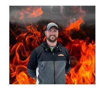 Casey, male crew chief smiling and standing fake fire background
